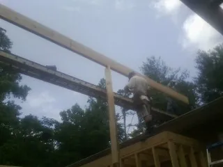 Carpenter setting a ridge beam over a new addition frame — Ice Dam Removal by Roofing Brothers in Sunfield