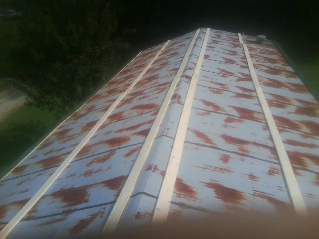Rusted metal roof panels with new wood purlins before replacement — Storm Damage Roof Repair in Sunfield by Roofing Brothers